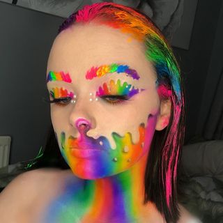 A woman with colorful makeup on her face.