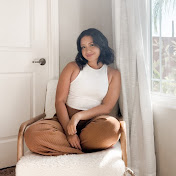 A woman sitting on a chair in front of a window.