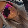 A woman wearing pink sunglasses in a car.