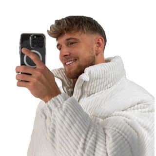 A man wearing a white jacket taking a selfie with his phone.