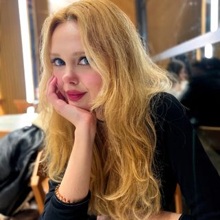 A woman with long blonde hair sitting at a table.