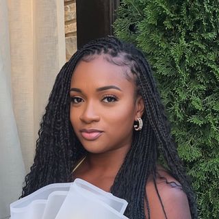 A young woman wearing a white dress with braids.