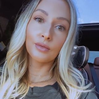 A woman sitting in a car with blond hair.