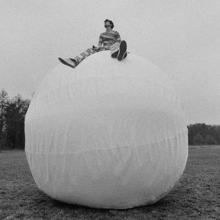 A man sitting on a large white ball.