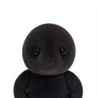 A black stuffed animal sitting on a white background.