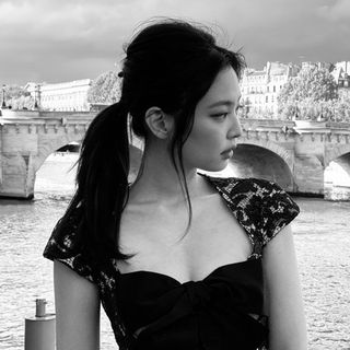 A black and white photo of a woman in a black dress.