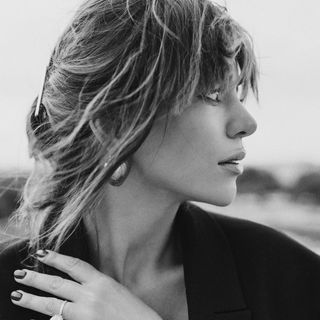 A black and white photo of a woman with a ring on her finger.