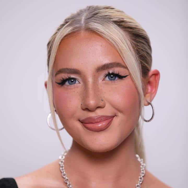 A woman with blue eyes and blond hair posing for a photo.