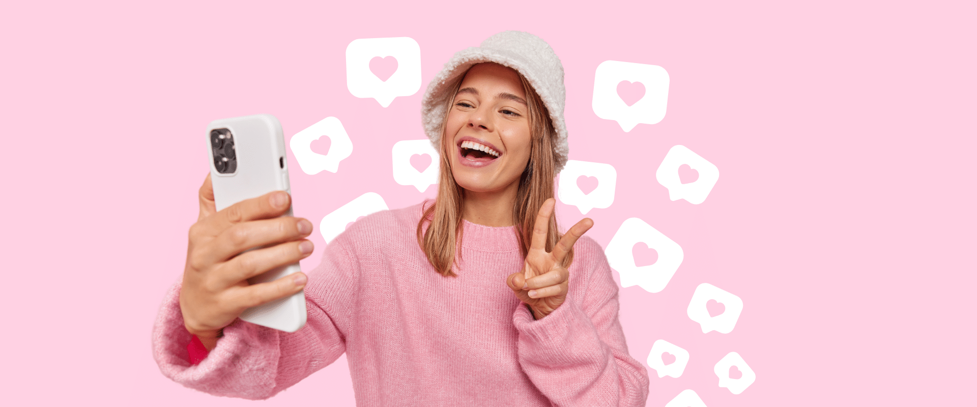 A girl is taking a selfie on a pink background.