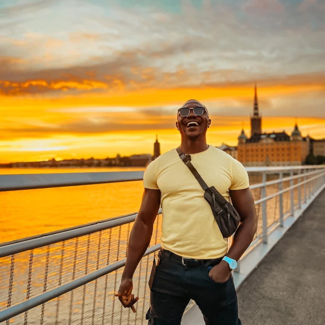A man is standing on a bridge at sunset in stockholm, sweden.