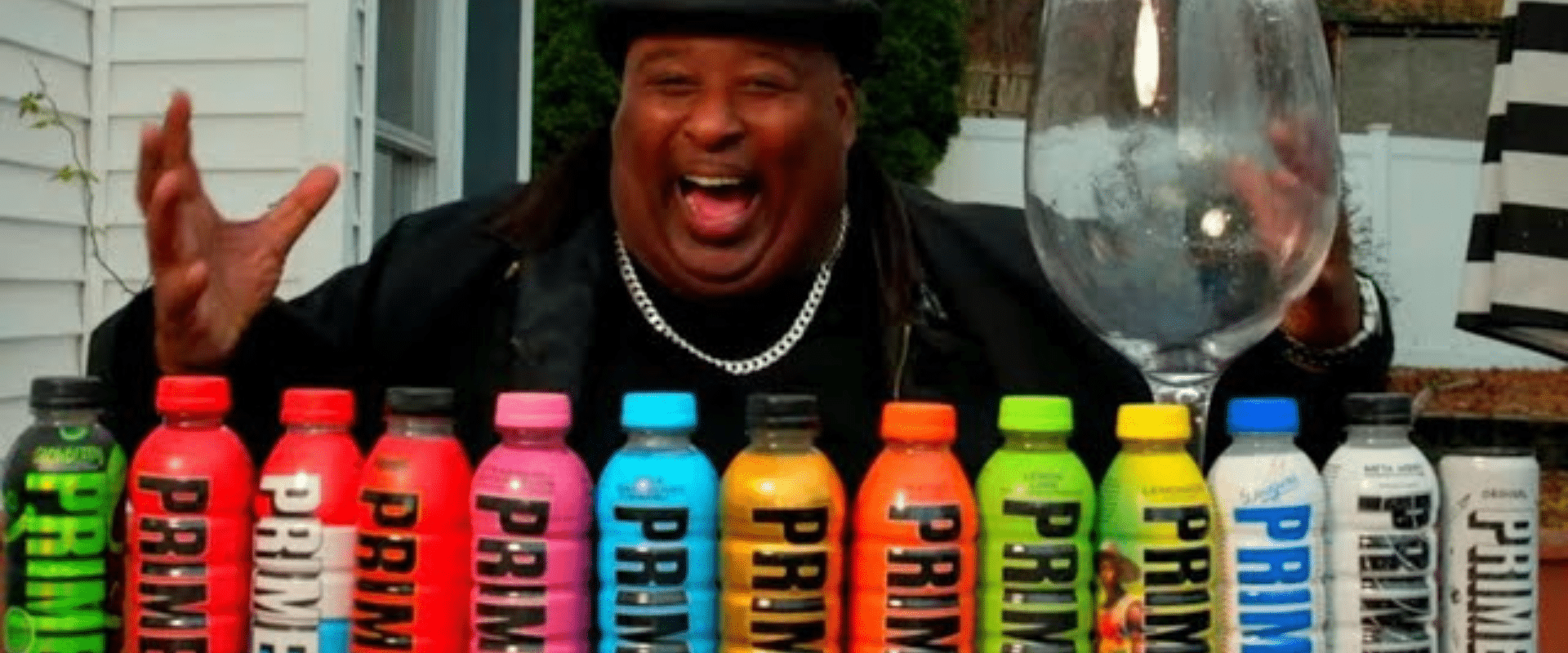 A man is standing in front of a bunch of colorful bottles.