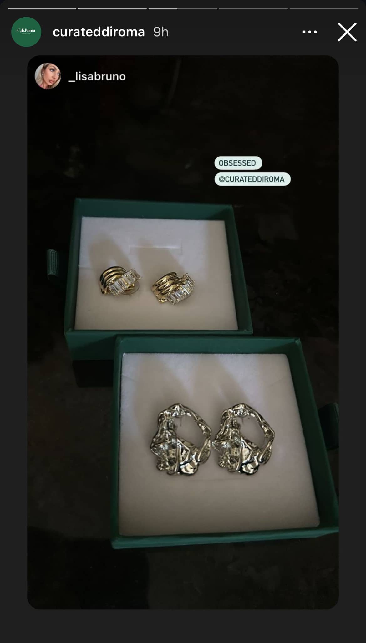 Two pairs of earrings are displayed in open jewelry boxes. The top box holds gold earrings with a textured design, and the bottom box holds silver earrings with a unique, irregular shape.